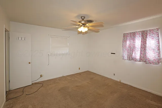 a view of a livingroom with a ceiling fan and window