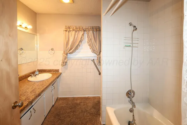 a bathroom with a tub sink and mirror