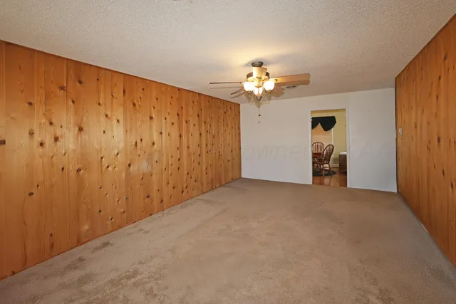 a view of an empty room with a chandelier fan