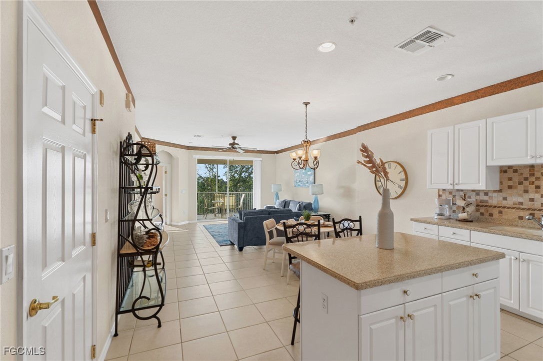 14981 Reflection Key Circle, Unit 335 Fort Myers, FL 33907 - Photo 14 of 42 a kitchen with a sink a table and chairs