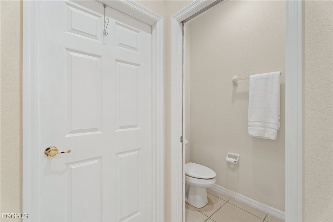 14981 Reflection Key Circle, Unit 335 Fort Myers, FL 33907 - Photo 26 of 42 a bathroom with a granite countertop toilet and a shower
