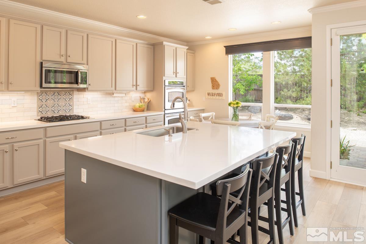 410 Shire Court Reno, NV 89521 - Photo 8 of 40 a kitchen with stainless steel appliances granite countertop a table chairs sink and cabinets