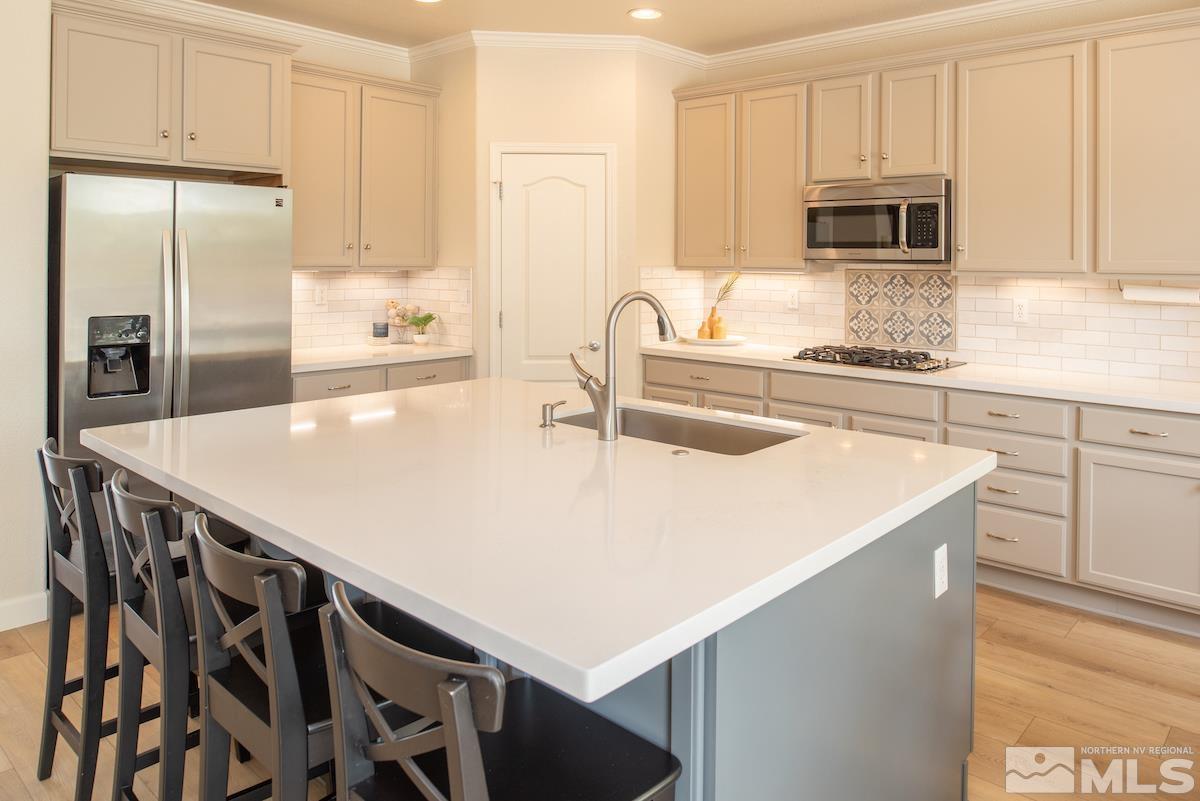 410 Shire Court Reno, NV 89521 - Photo 10 of 40 a kitchen with stainless steel appliances a stove a sink a microwave and cabinets