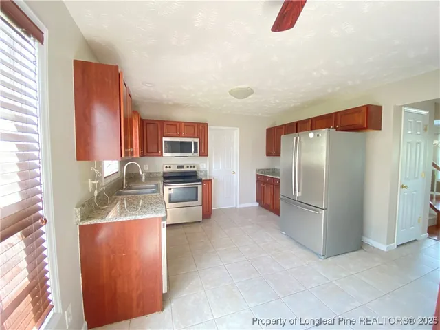 a kitchen with stainless steel appliances granite countertop a refrigerator and a stove