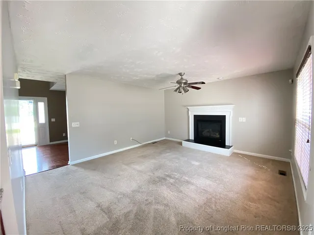 an empty room with fireplace and windows