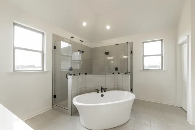 a white bath tub sitting in a bathroom next to a window