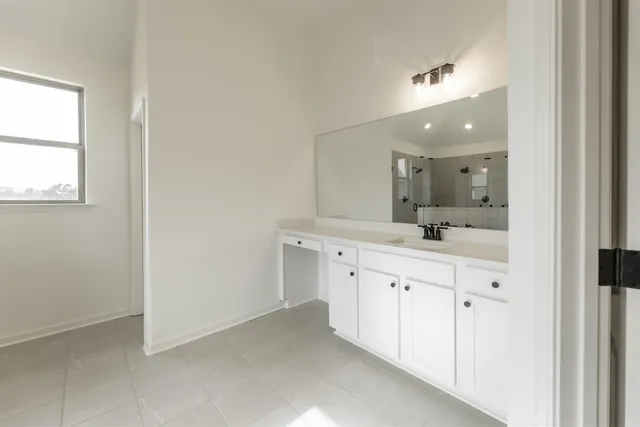 a spacious bathroom with a double vanity sink and a mirror