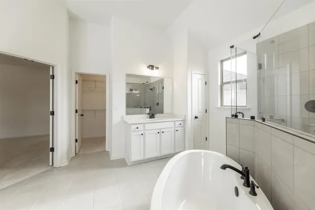 a spacious bathroom with a tub sink shower and mirror