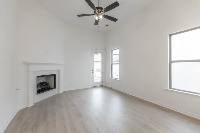 an empty room with windows and a fireplace