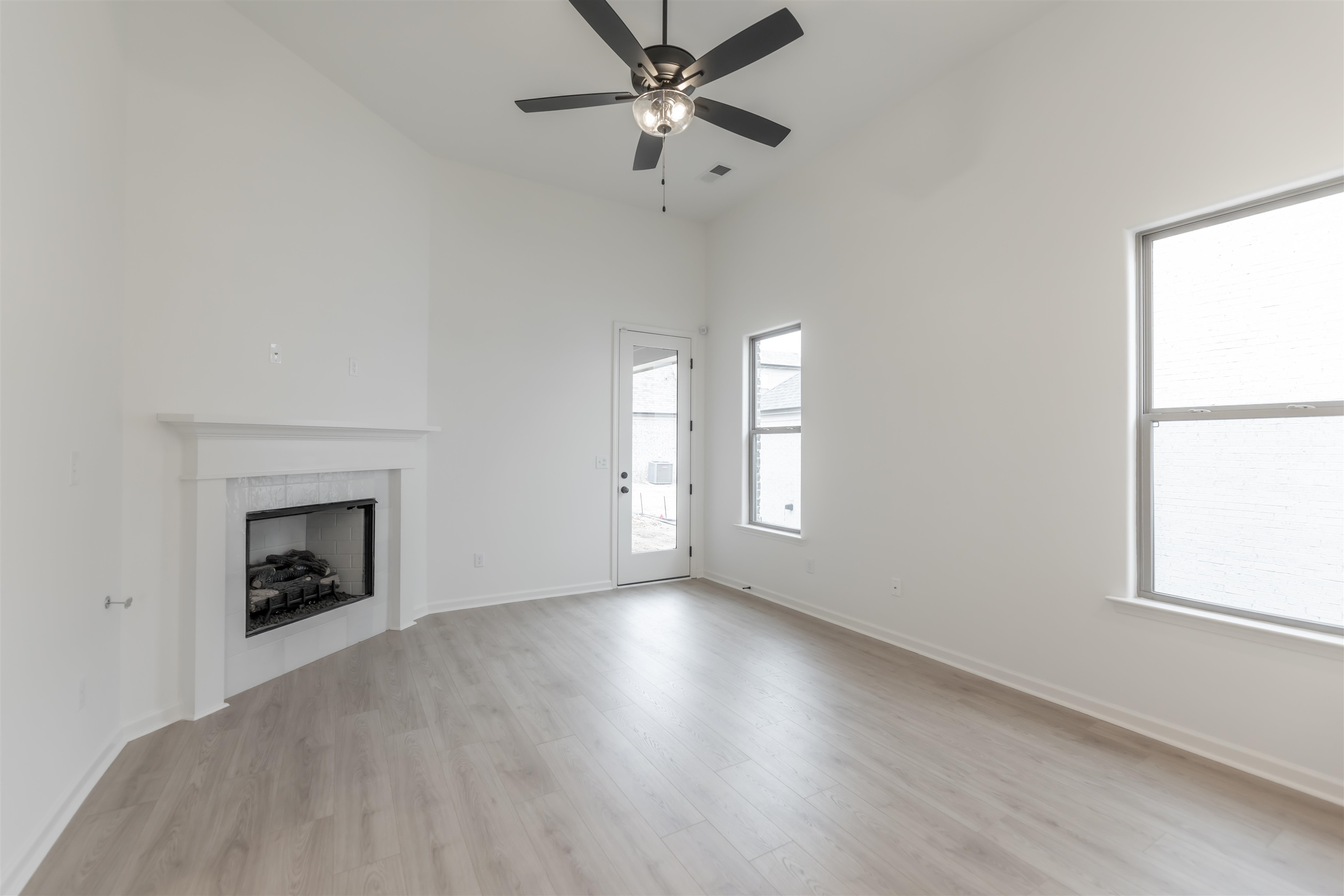 22 Doral Loop Oakland, TN 38060 - Photo 4 of 27 an empty room with windows and a fireplace