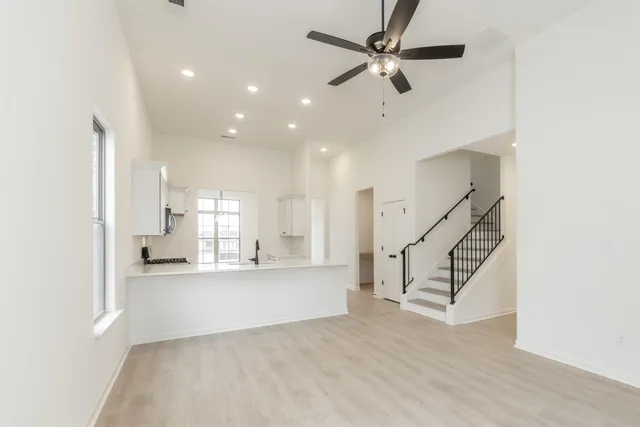 a view of a kitchen with wooden floor and a ceiling fan