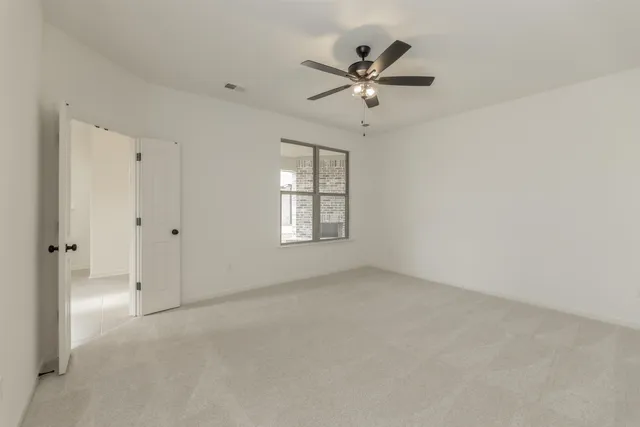 an empty room with windows and fan