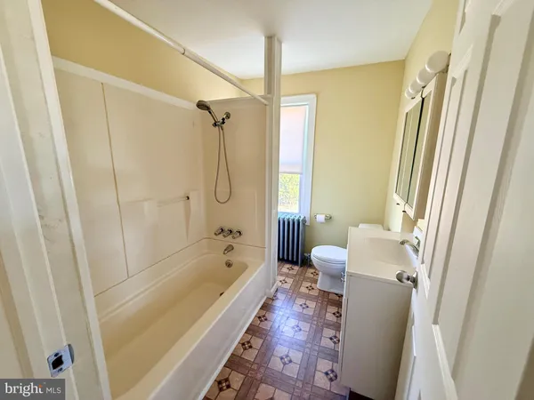 a bathroom with a tub shower and a sink