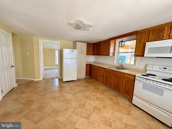 a kitchen with a stove a sink and a refrigerator