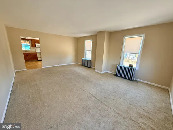 an empty room with windows and cabinet