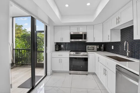 a kitchen with a sink stove top oven and refrigerator