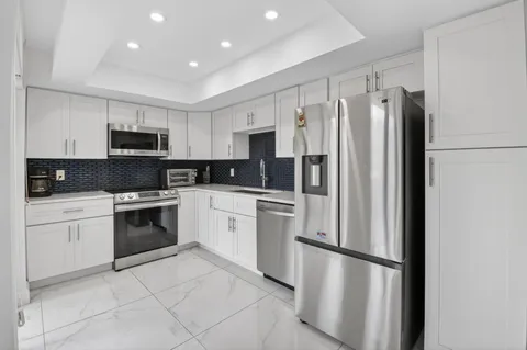 a kitchen with stainless steel appliances granite countertop a refrigerator sink and stove