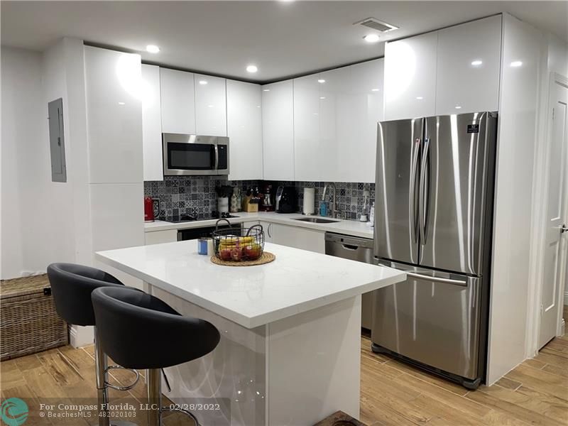 a kitchen with stainless steel appliances granite countertop a sink a stove a refrigerator and a refrigerator