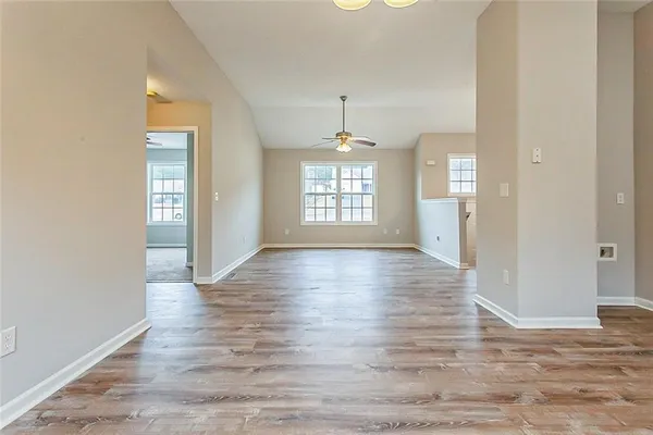 an empty room with wooden floor and windows