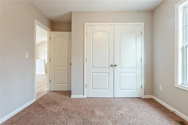 an empty room with windows and closet