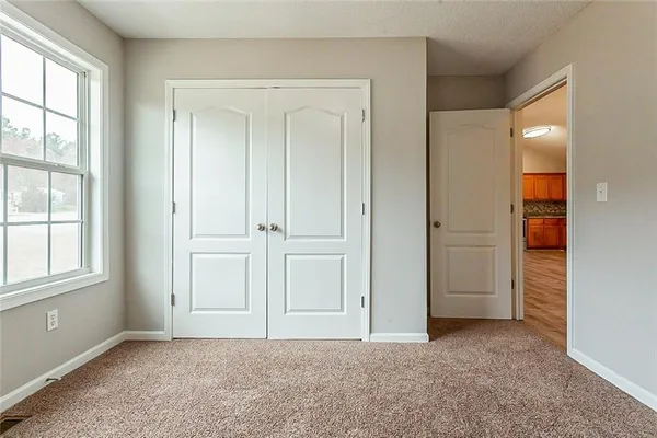 an empty room with windows and closet