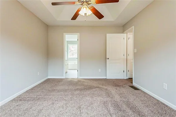an empty room with a window and ceiling fan