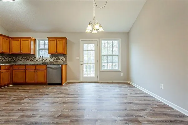 a view of a kitchen with granite countertop cabinets and wooden floor
