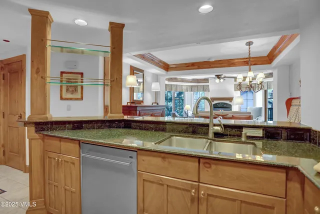 a kitchen with stainless steel appliances granite countertop a sink and a refrigerator