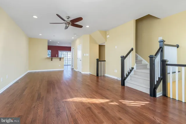 a view of a livingroom with wooden floor and a ceiling fan