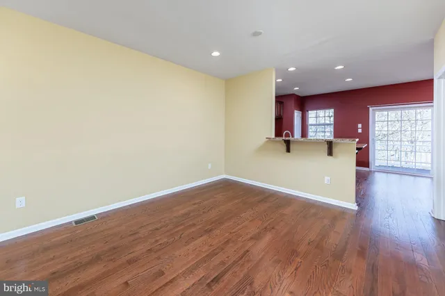 a view of a kitchen with wooden floor and a window