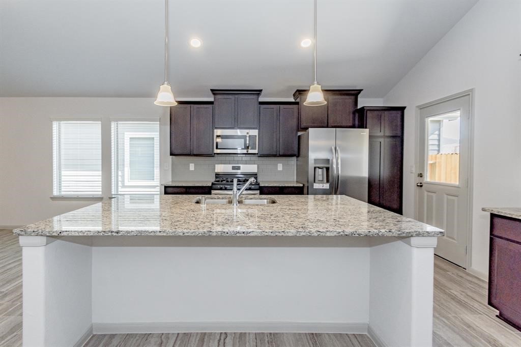 6447 Escondido Drive Rosharon, TX 77583 - Photo 4 of 16 An entertainer’s dream! The open-concept layout seamlessly connects the living, dining, and kitchen areas, offering a harmonious flow that’s perfect for hosting gatherings or enjoying family time. Tile flooring adds a touch of modern elegance, while the neutral color palette creates a versatile canvas for any décor style. Experience the perfect balance of style and comfort in this stunning home.