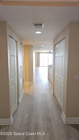 a view of a hallway with wooden shelves