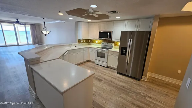 a kitchen with stainless steel appliances a refrigerator sink and microwave