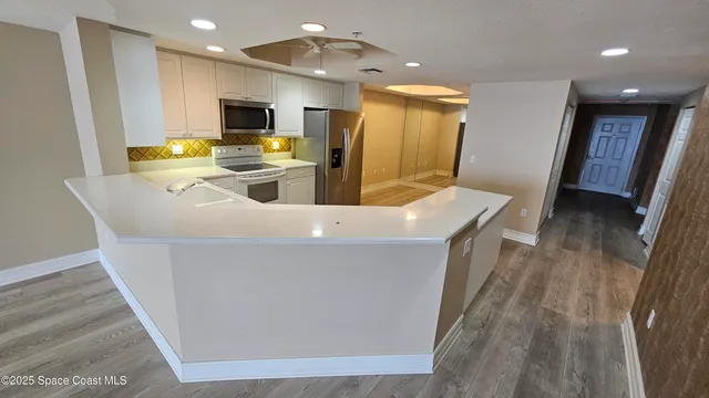 a kitchen with sink a refrigerator and chairs