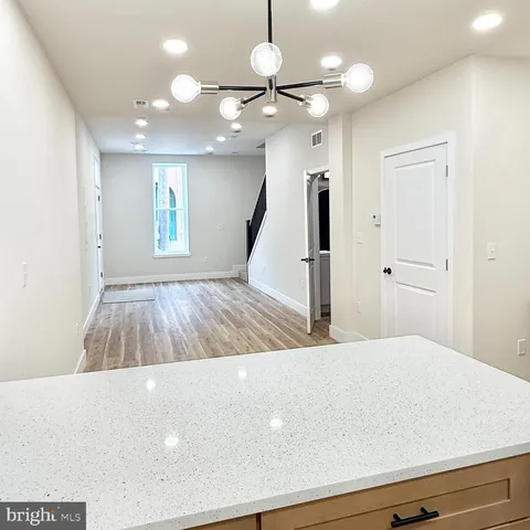 a view of a kitchen with a sink and chandelier