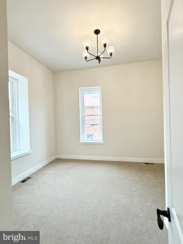 an empty room with windows and cabinet