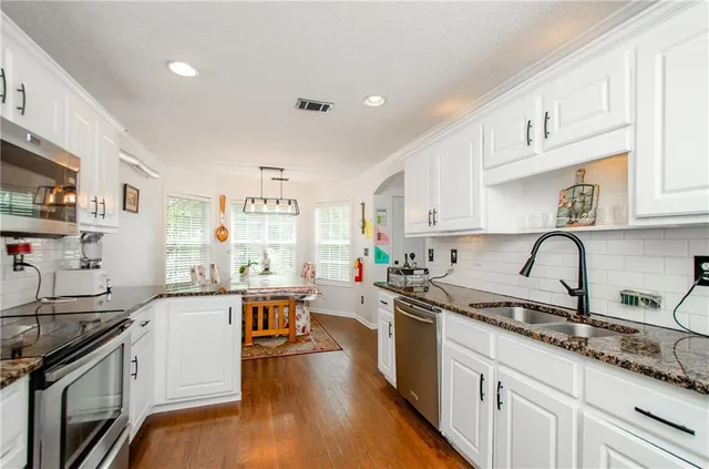 a kitchen with stainless steel appliances a sink stove and cabinets