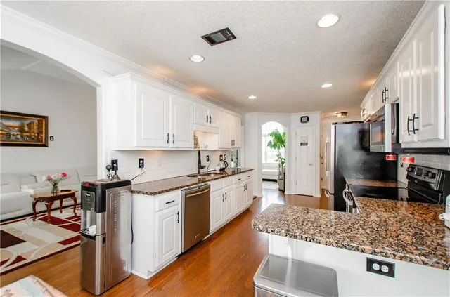 a kitchen with stainless steel appliances granite countertop a sink stove and refrigerator