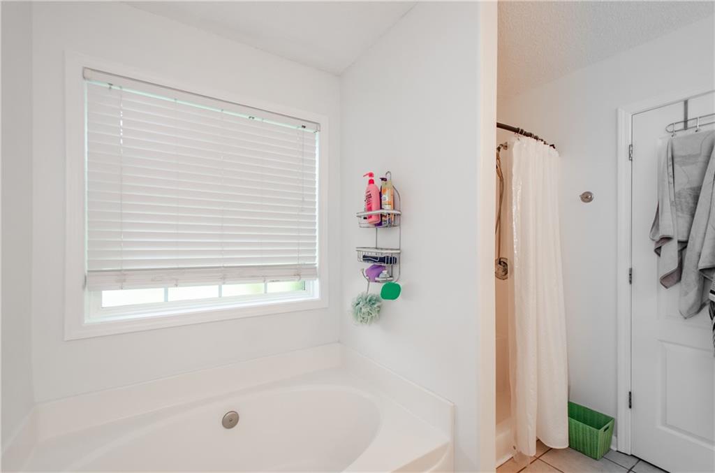 722 Moonlite Trace Winder, GA 30680 - Photo 22 of 41 a bathroom with a shower and a tub