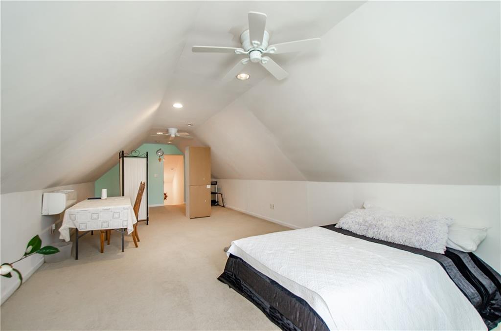 722 Moonlite Trace Winder, GA 30680 - Photo 28 of 41 a spacious bedroom with a bed a chandelier and window