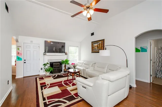 a living room with furniture a flat screen tv and a fireplace
