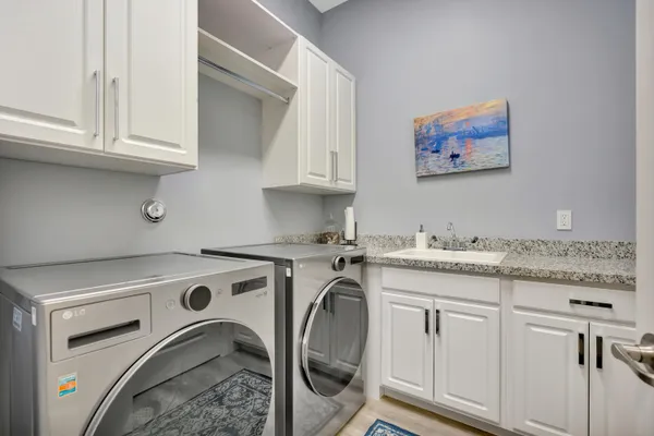 a utility room with stainless steel appliances granite countertop a stove a washer and dryer
