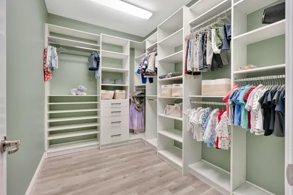 a view of walk in closet with clothes and shoes