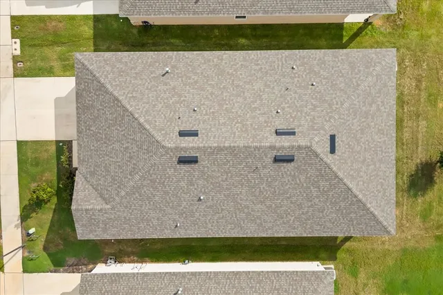 an aerial view of a residential houses with yard