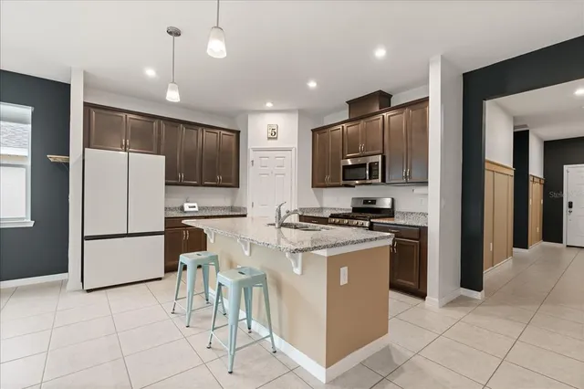 a kitchen with granite countertop a refrigerator and a stove top oven