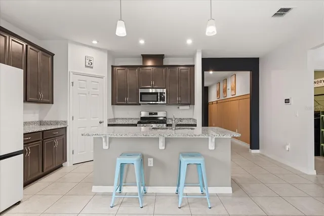 a kitchen with kitchen island granite countertop stainless steel appliances cabinets a sink and a counter top space