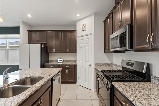 a kitchen with stainless steel appliances granite countertop a sink stove and refrigerator