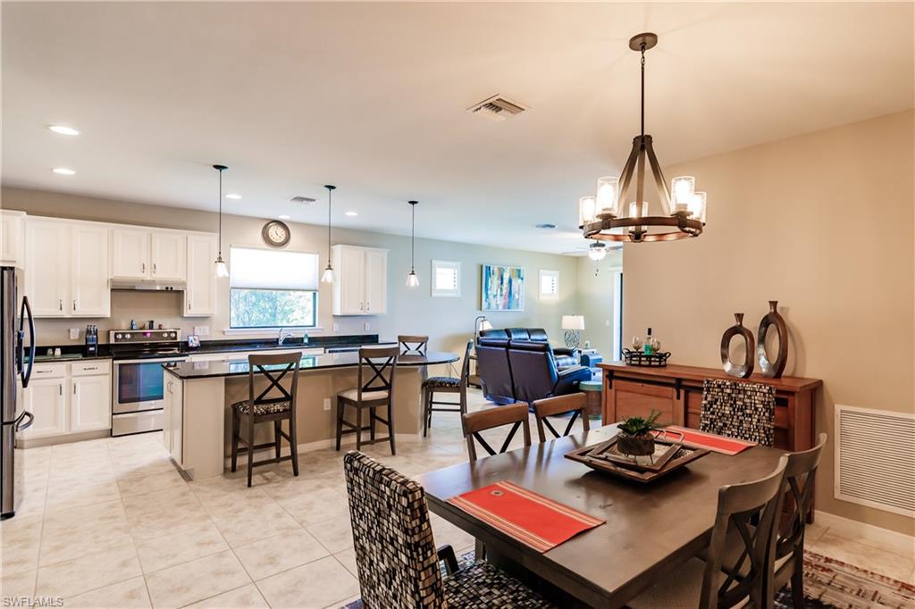 10883 Dennington Road Fort Myers, FL 33913 - Photo 11 of 32 a view of a dining room and livingroom with furniture wooden floor a rug a chandelier
