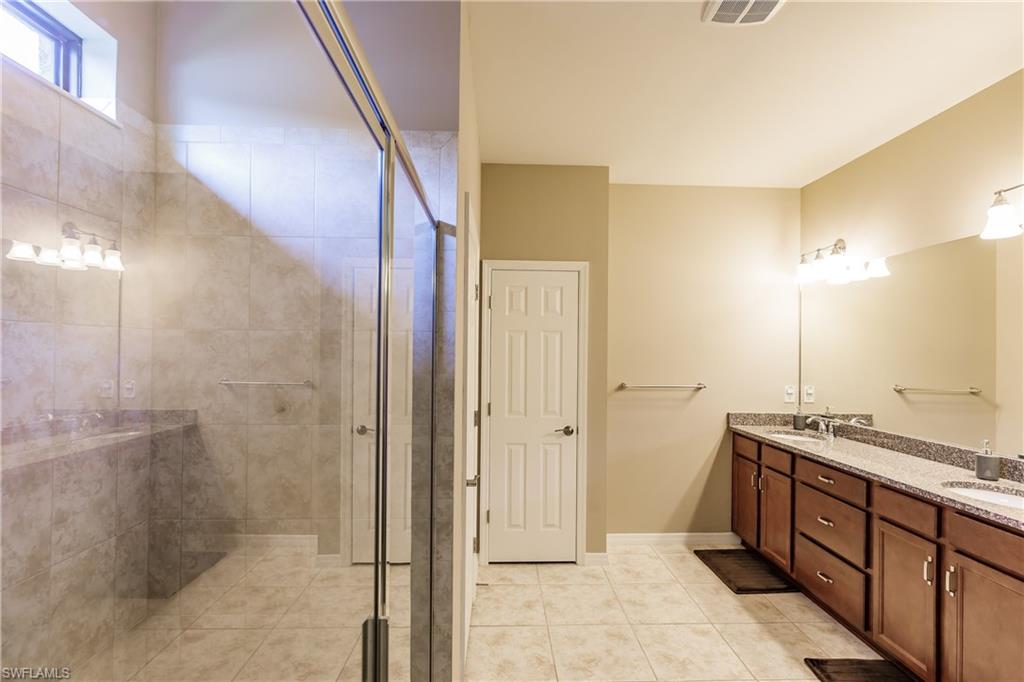 10883 Dennington Road Fort Myers, FL 33913 - Photo 15 of 32 a bathroom with a granite countertop sink a mirror and a shower