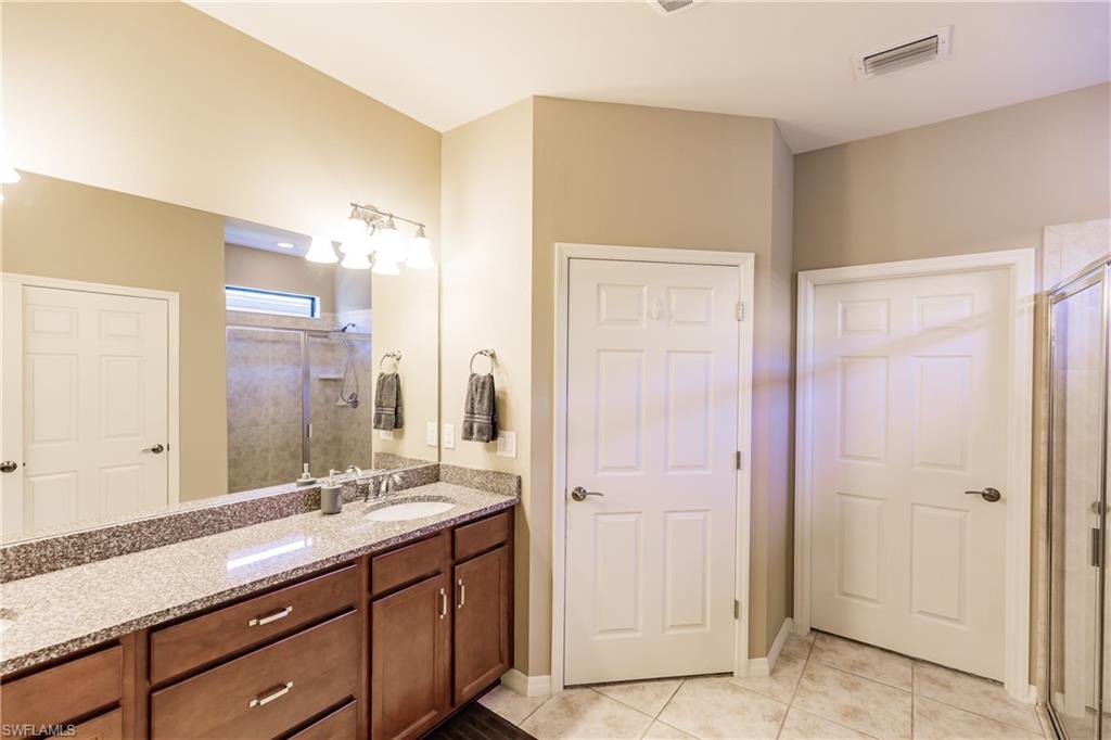 10883 Dennington Road Fort Myers, FL 33913 - Photo 16 of 32 a bathroom with a double vanity sink and a mirror